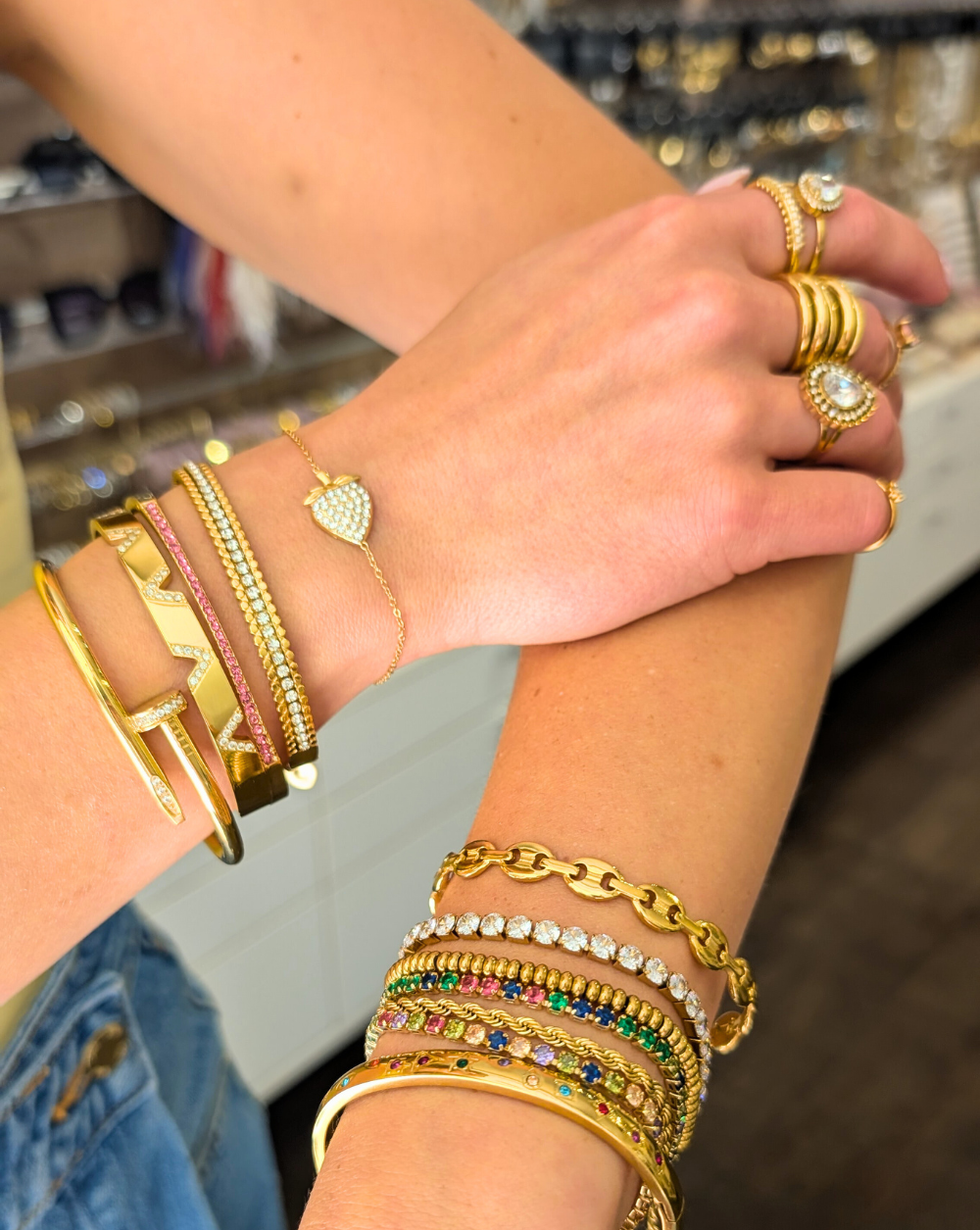 Buntes Styling von Armbändern und Ringen in Gold, mit funkelnden Kristallen, Herzen und geometrischen Motiven - Modekombinationen von Patrizia Ljubljana.