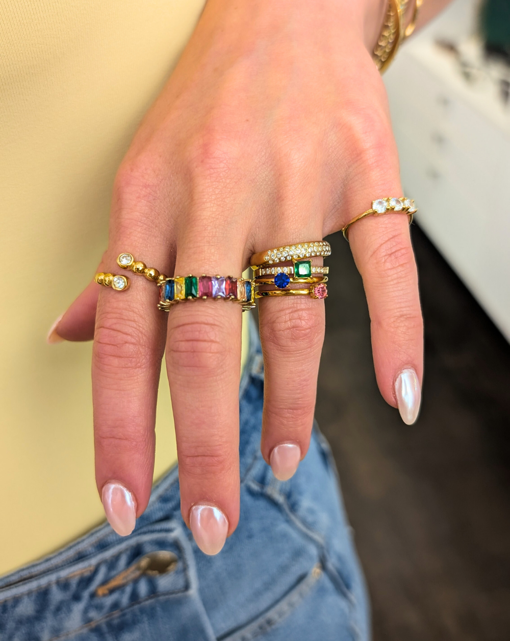 Eine modische Kombination aus mehreren vergoldeten Ringen mit farbigen und transparenten Kristallen an der Hand - aus der Kollektion Patrizia Ljubljana.