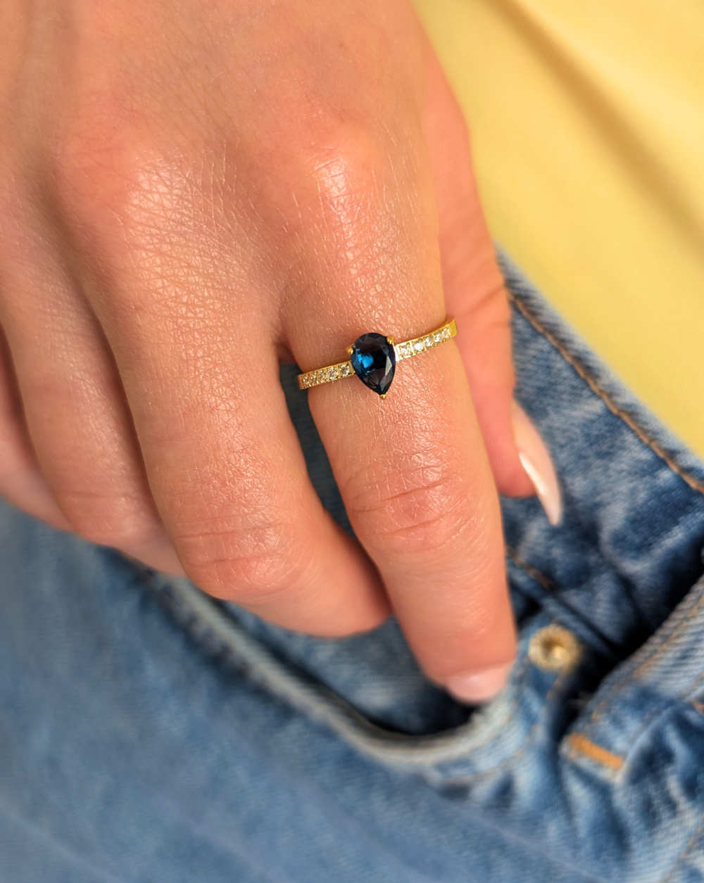 Prstan iz nerjavečega jekla s temnim kapljičastim kamnom in kristali ob strani – eleganten kos iz trgovine Patrizia Ljubljana.