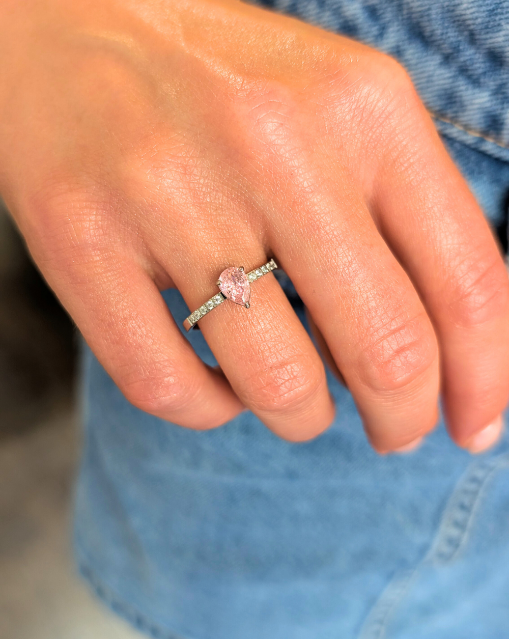 Prstan iz nerjavečega jekla z drobnimi kristali in kapljičastim rožnatim kamnom v središču – eleganten kos iz kolekcije trgovine Patrizia Ljubljana.