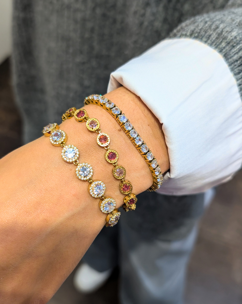 Three stainless steel bracelets in gold - two with round cubic zirconia in clear and pink and one with a classic set of white cubic zirconia, an elegant combination of sparkling Patrizia jewellery pieces.