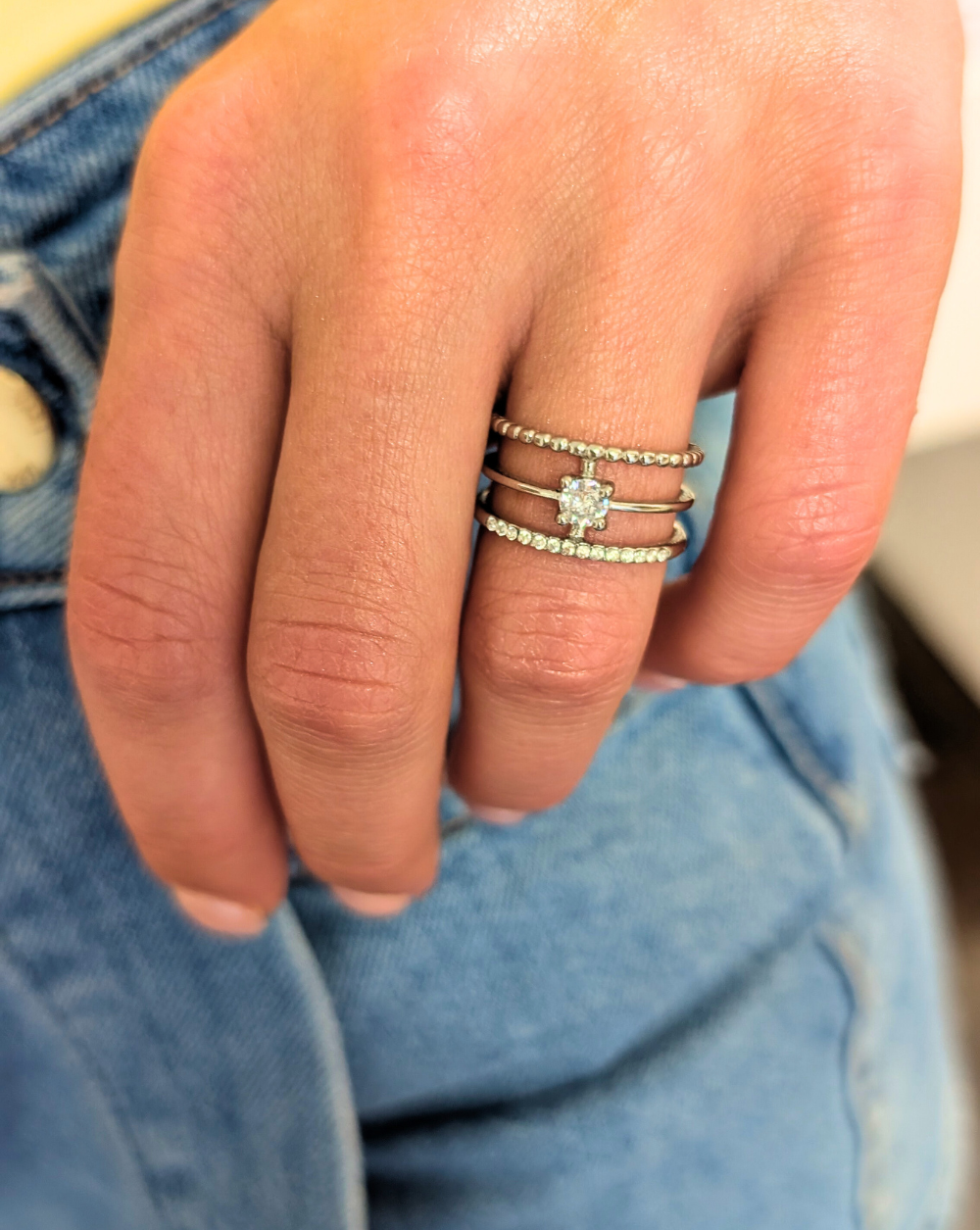 Ring aus Edelstahl mit drei Reihen von Kristallen und einem akzentuierten Mittelstein - ein elegantes, mehrschichtiges Schmuckstück von Patrizia Ljubljana.