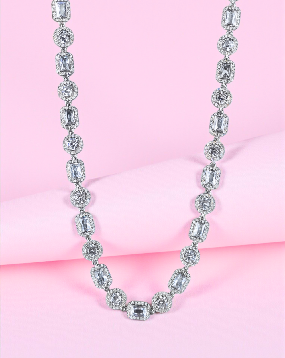 Verižica GLACIER iz nerjavečega jekla s pavé in emerald cirkoni, prikazana na rožnatem ozadju – Trgovina Patrizia Ljubljana.