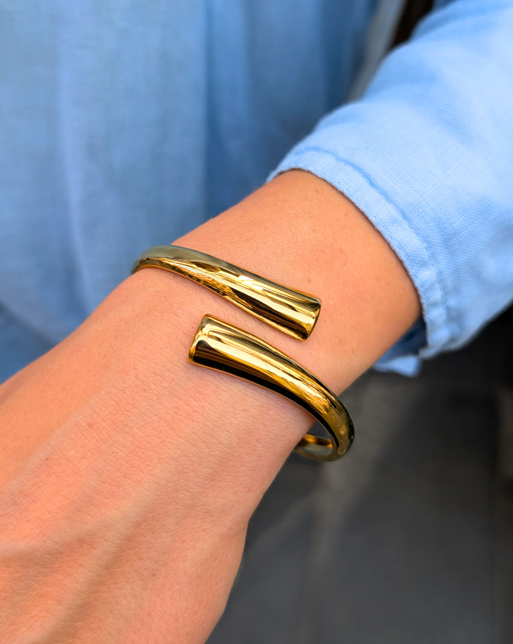 Odprta zapestnica iz nerjavečega jekla z gladkim, sijočim zaključkom in sodobno obliko – statement kos iz trgovine Patrizia Ljubljana.