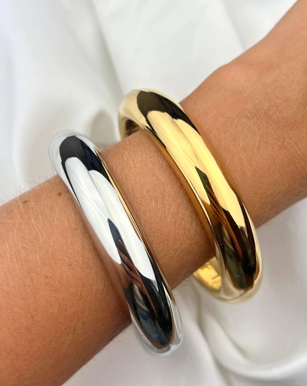 Massives Armband SOLID BANGLE aus glänzendem Edelstahl, um das Handgelenk geschnallt - Trgovina Patrizia Ljubljana.