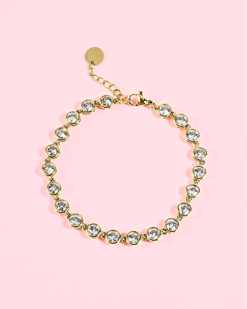 Zlata kristalna zapestnica “Solitaire” iz nerjavečega jekla na rožnatem ozadju – Trgovina Patrizia Ljubljana.