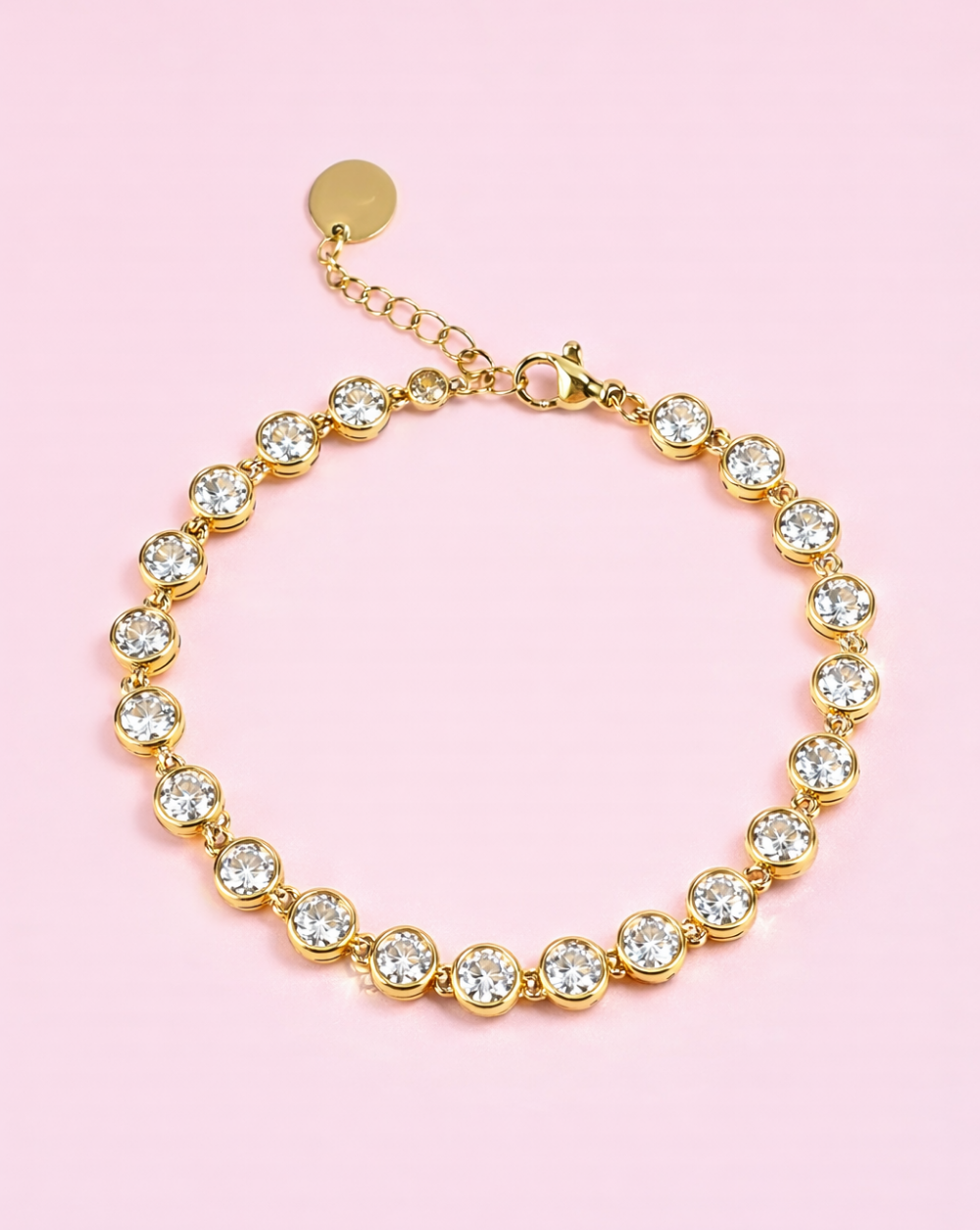 Zlata kristalna zapestnica “Solitaire” iz nerjavečega jekla na rožnatem ozadju – Trgovina Patrizia Ljubljana.