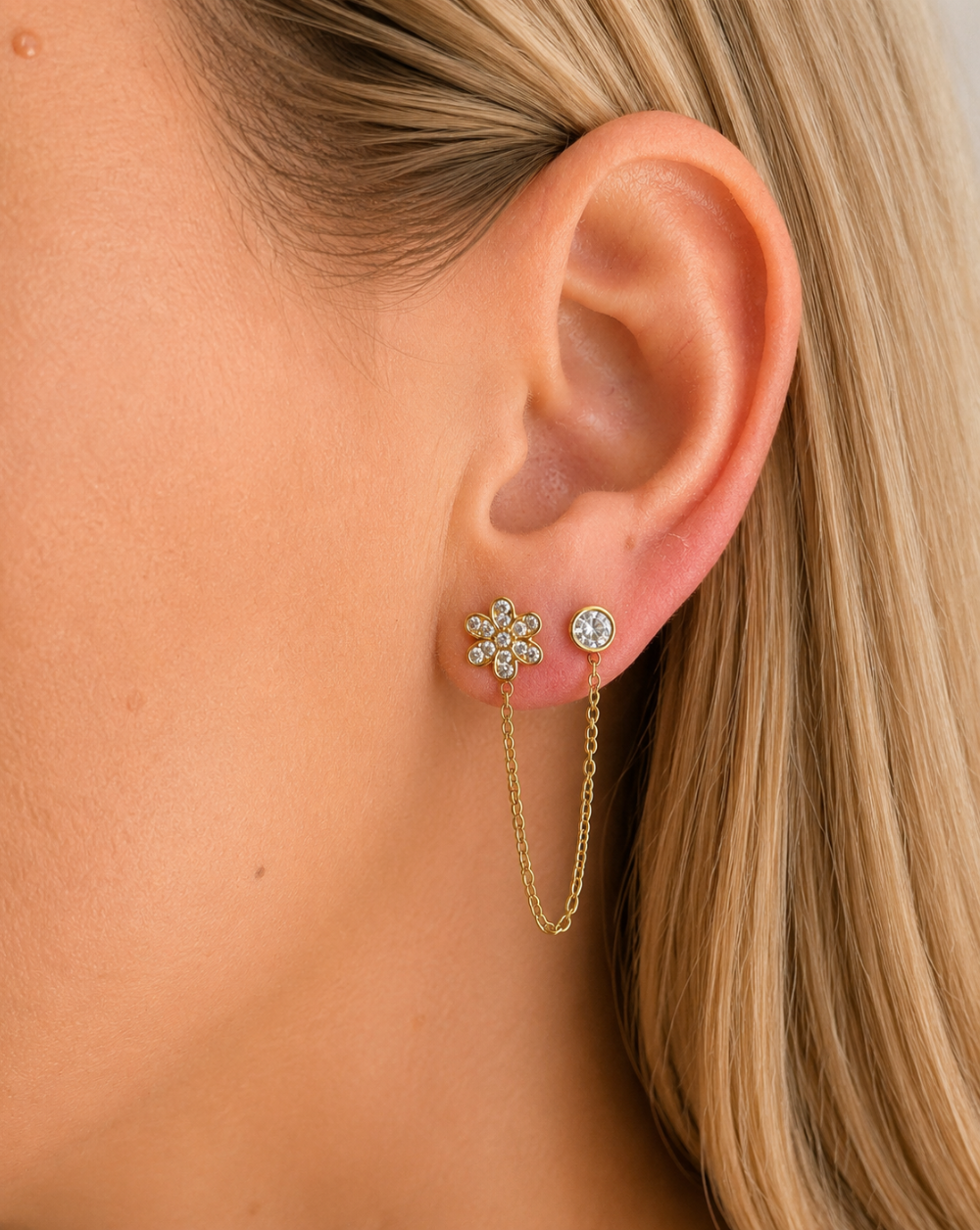 Modni uhani z verigo DAISY iz nerjavečega jekla – uhani s cvetličnim motivom, elegantno verižico in sijočimi kamenčki za prefinjen videz in popoln ear stack. Trgovina Patrizia Ljubljana.