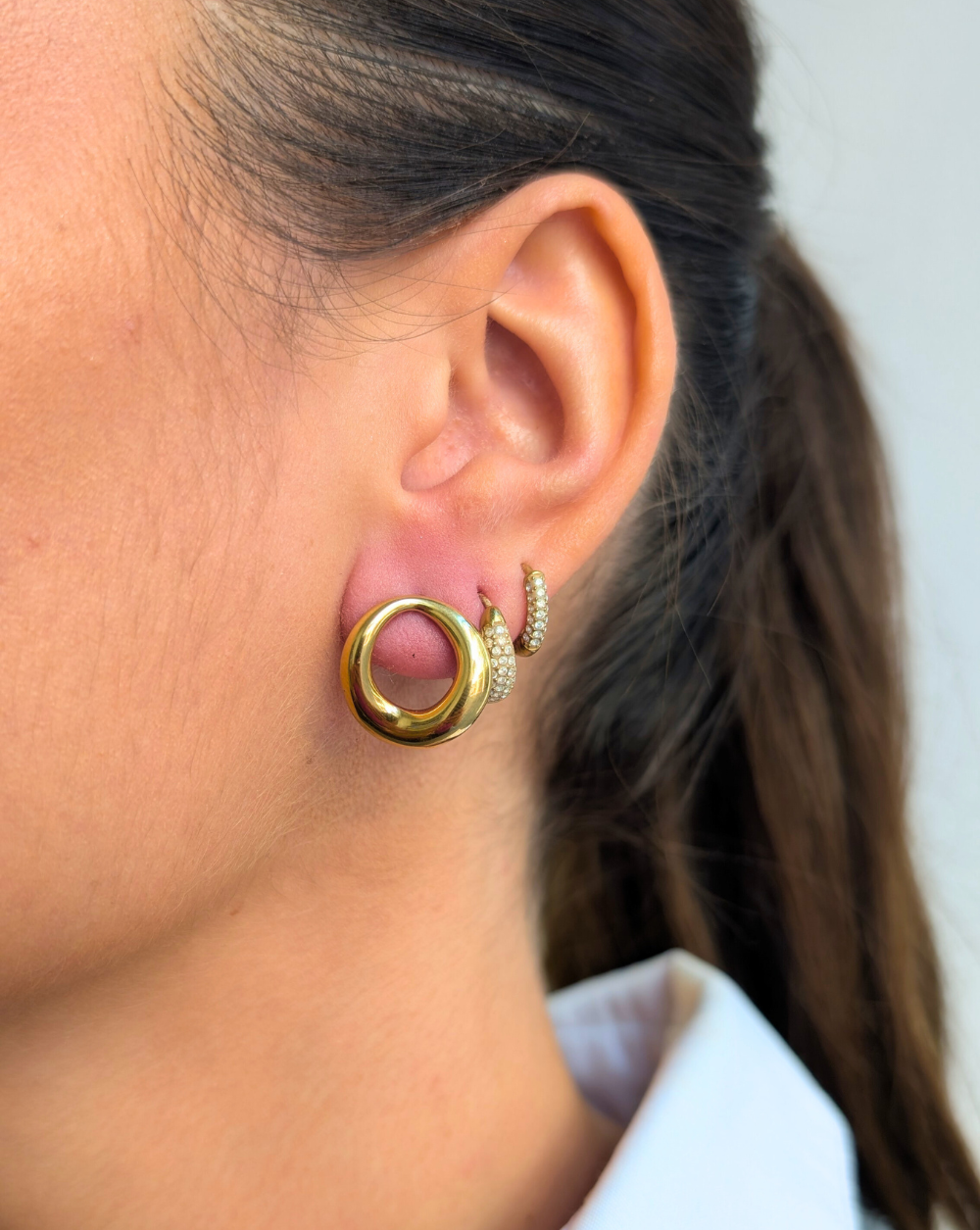 MALE PETLICE od nehrđajućeg čelika, elegantne manje zlatne naušnice zaobljenog oblika iz trgovine Patrizia Ljubljana za svakodnevni i sofisticirani izgled.