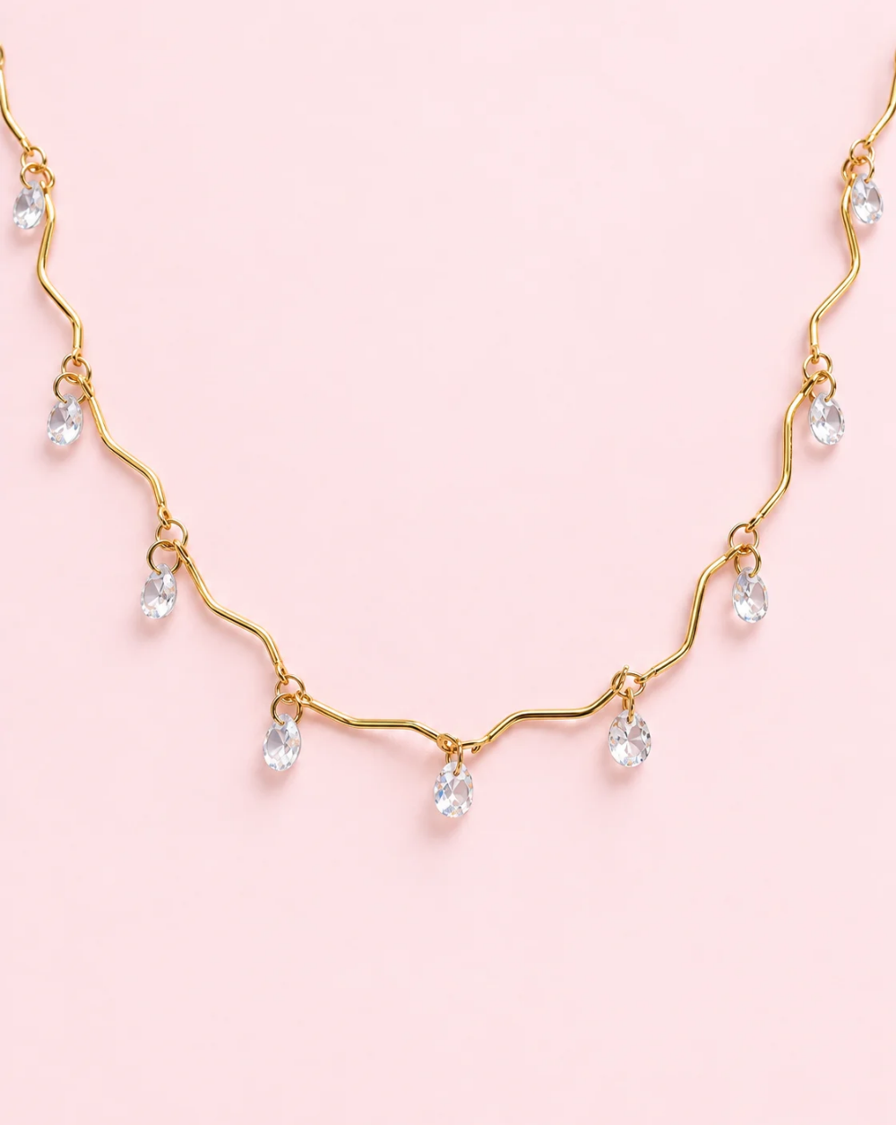 Halskette CRYSTAL WAVE aus Edelstahl mit gewellten goldenen Gliedern und herabhängenden transparenten Kristallchen – Trgovina Patrizia Ljubljana.