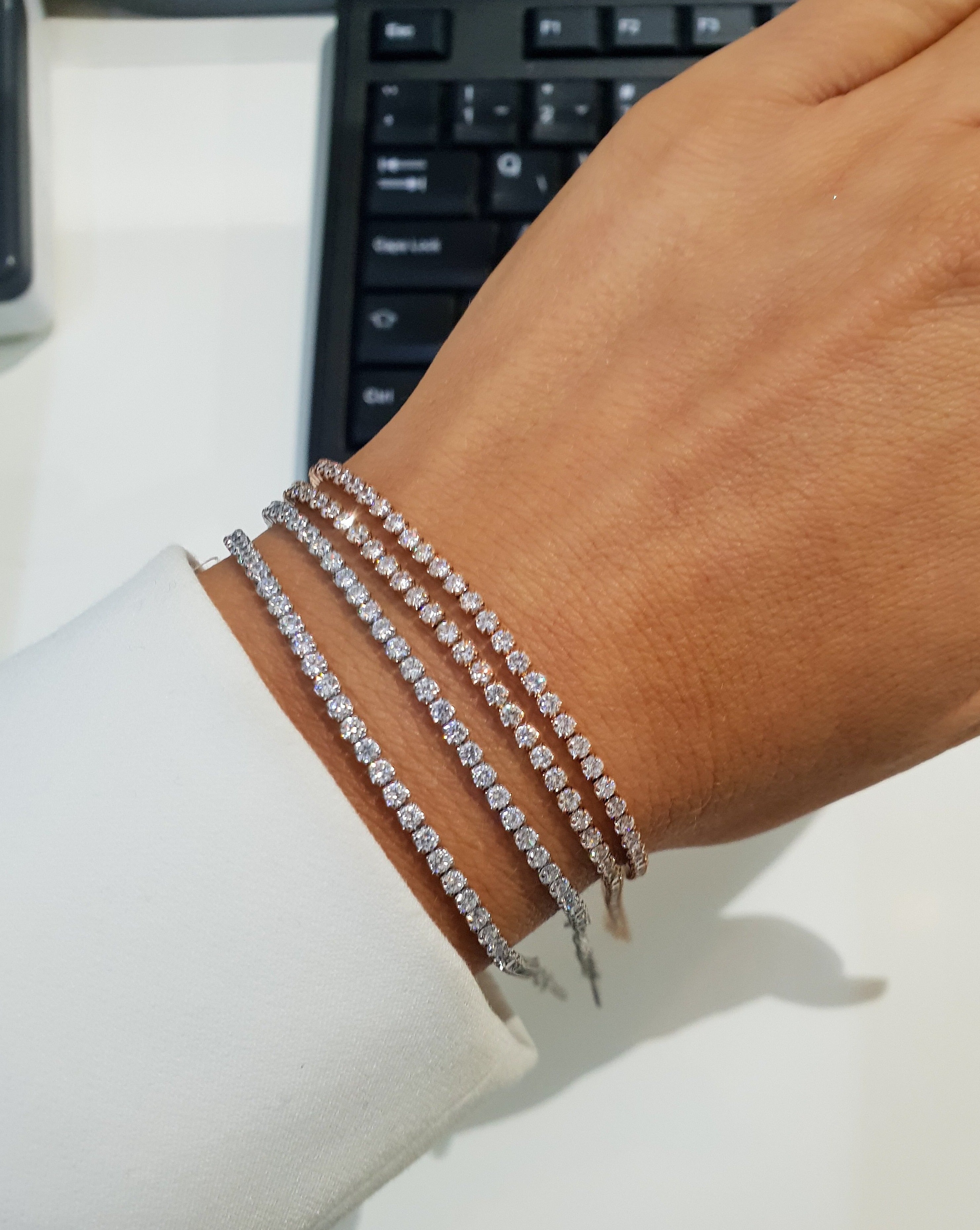 Armband Roségold Tennis mit Strasssteinen in Silber und am Handgelenk.