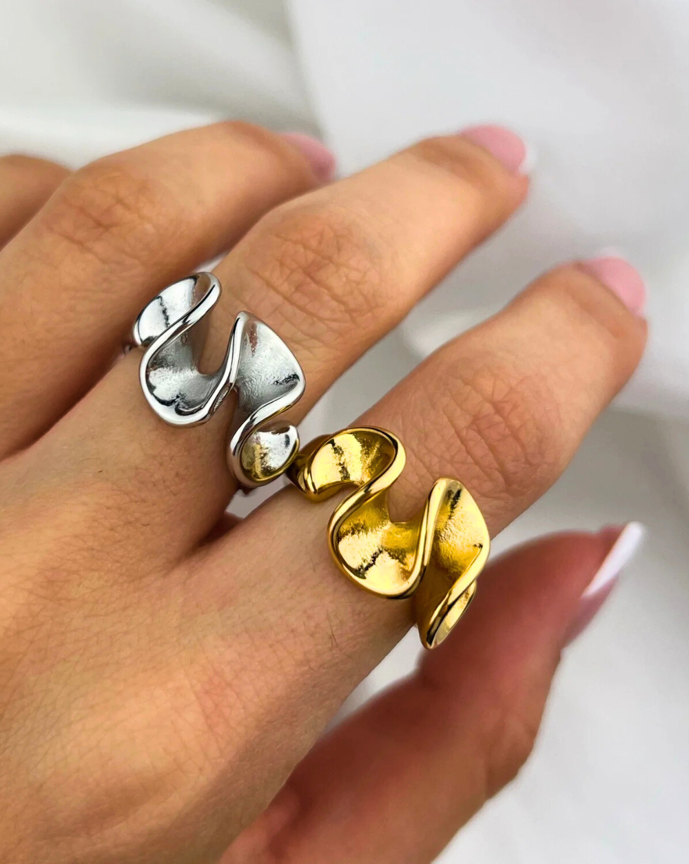 Valovit prstan WAVY SCULPT iz nerjavečega jekla v dveh izvedbah, prikazan na roki modela – Trgovina Patrizia Ljubljana.