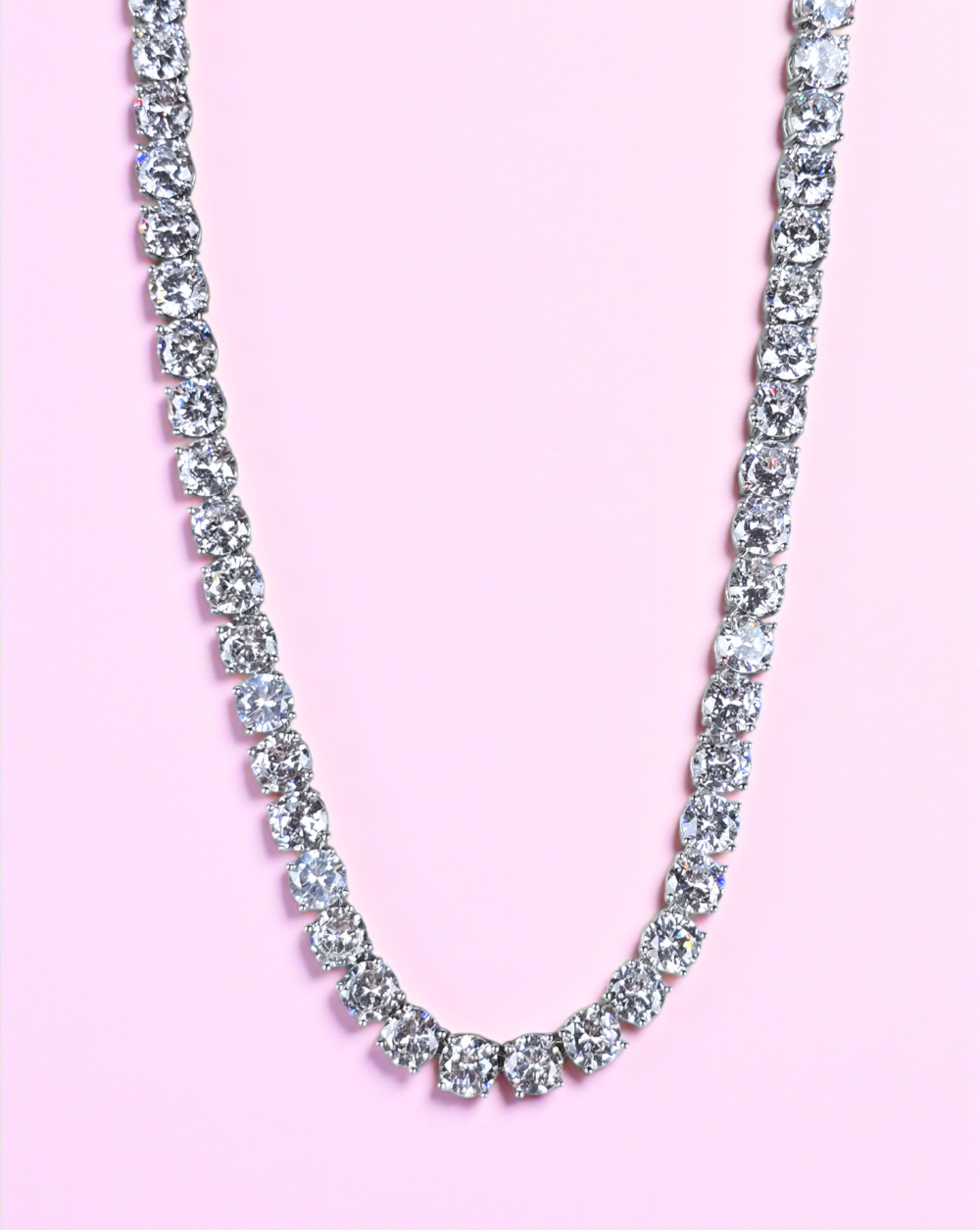 Necklace made of rhodium-plated metal with maximum shine and sparkling zircons on a pink background – Trgovina Patrizia .