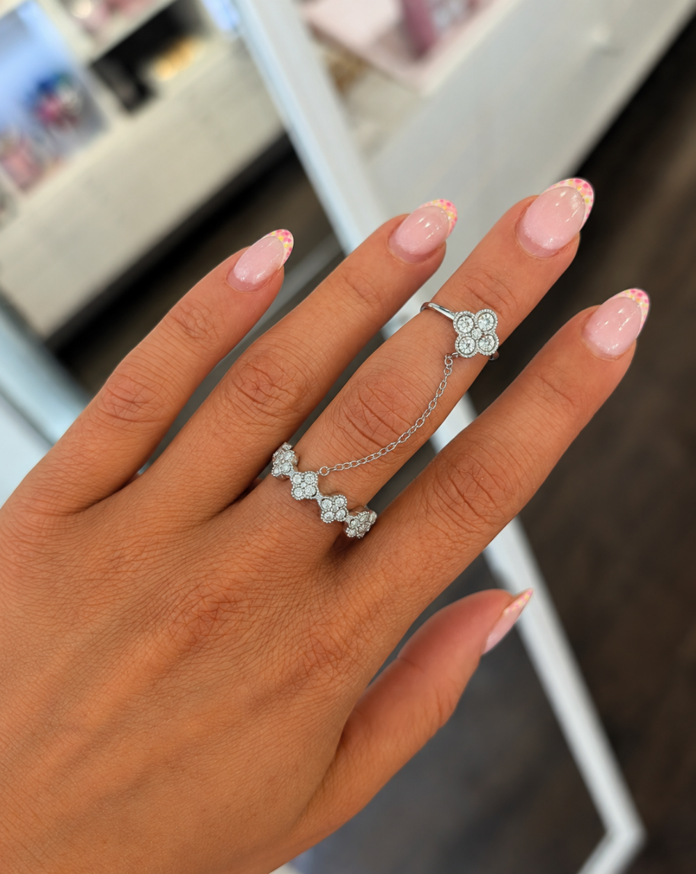 Silver cuff Ring GLAM  FLOWERS  made of stainless steel with two rings connected by chains and floral motifs made of clear crystals – Trgovina Patrizia Ljubljana.