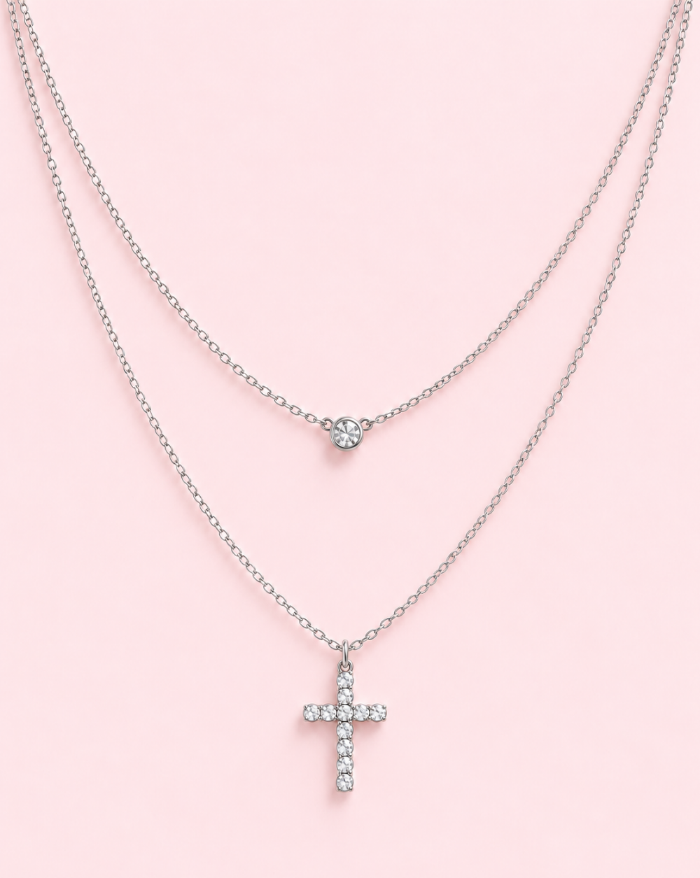 Dvojna verižica CRYSTAL CROSS iz nerjavečega jekla z dvema verižicama različnih dolžin, okroglim cirkonom in visečim križcem, okrašenim z bleščečimi kamenčki – Trgovina Patrizia Ljubljana.