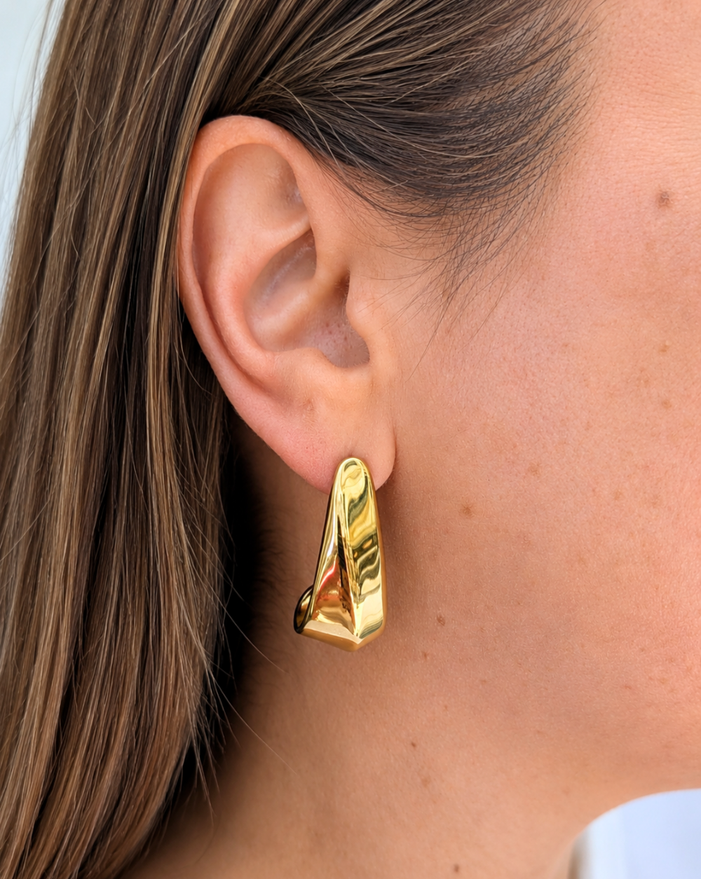 Die Ohrringe SCULPT aus goldfarbenem Edelstahl mit markantem geometrischem Design – elegante und gewagte Modeohrringe aus dem Geschäft Patrizia Ljubljana für einen modernen Look.